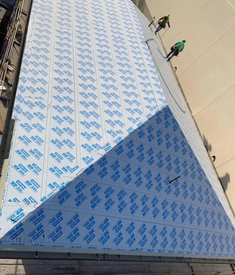 Professional roofers installing underlayment on a metal roof in Cumberland